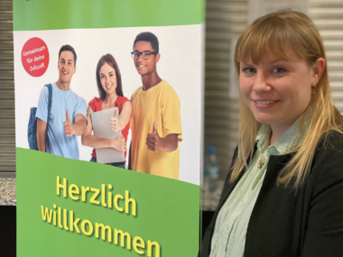 Die QuABB-Ausbildungsbegleiterin vor einem Roll-up bei der langen Nacht der Ausbildung